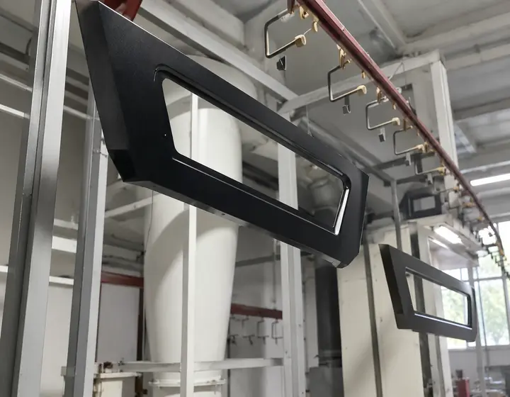 Black powder coated truck canopy frames hanging on an overhead production line